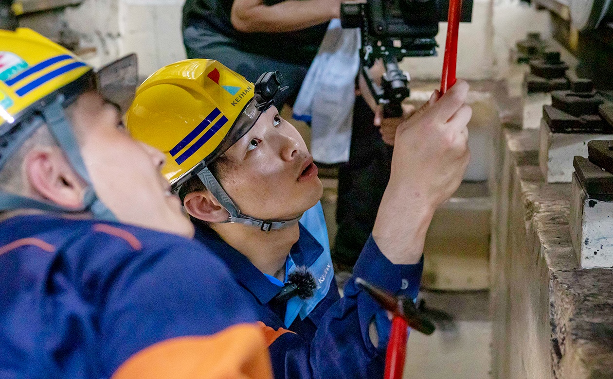 床下にもぐって点検作業を行う西川選手。鎌田さんの説明に耳を傾ける姿は真剣そのもの。