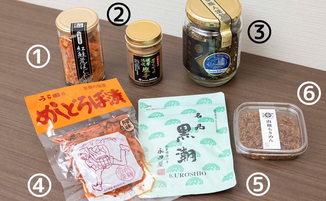 ①『紅鮭荒ほぐし／1瓶170ｇ・1,781円』、②『昔ながらの濃厚熟成塩辛／1本・1,080円』、③『百年ふりかけ（納豆）／1瓶・999円』、④『めしどろぼ漬／120ｇ・273円』、⑤『名品 黒潮／70ｇ・756円』、⑥『山椒ちりめん／50g・411円』（いずれも取材時の価格）。