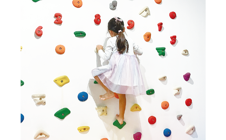 カラフルな石が配されたボルダリング遊具「ラクラクライム」で登るルートを考えながら遊べば、頭も体も鍛えられそう