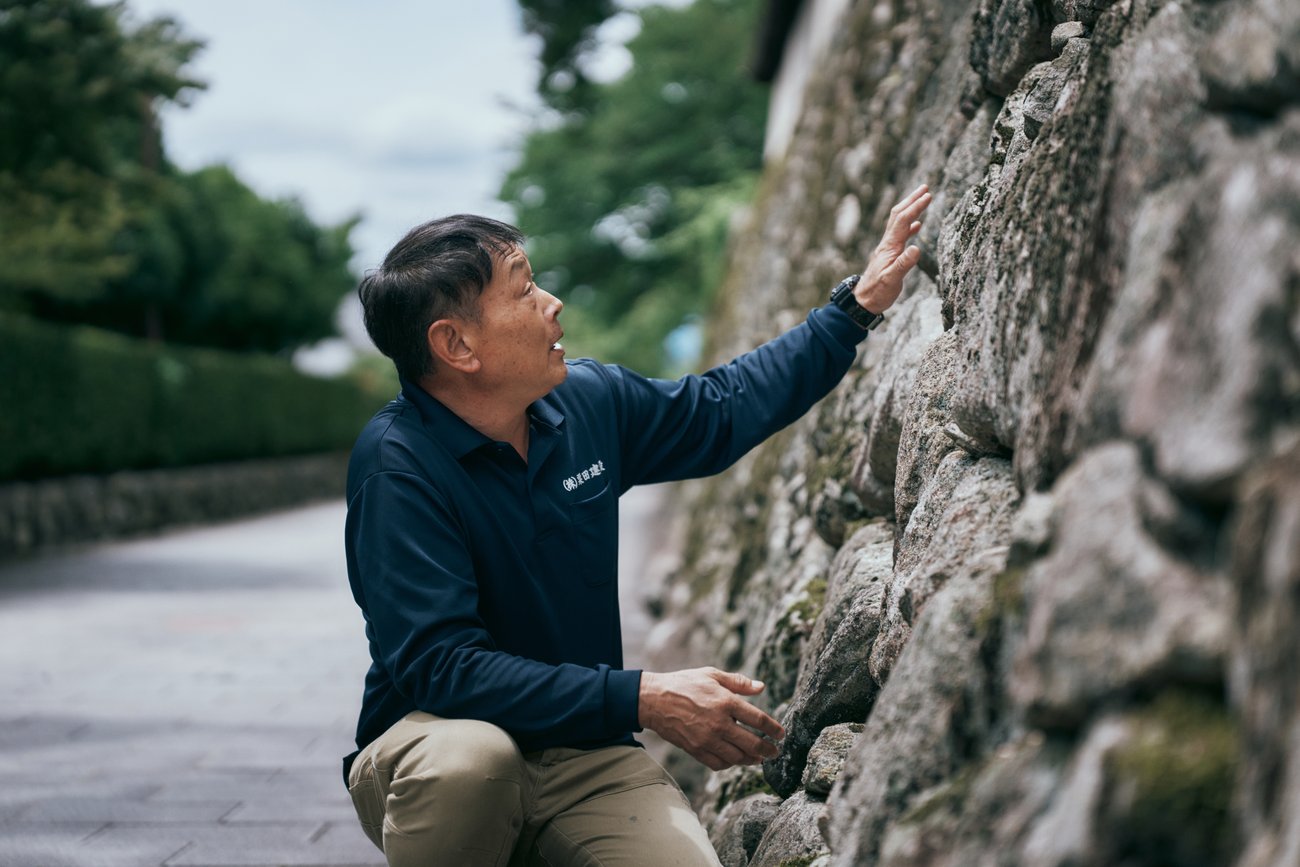 坂本の石垣を見つめる粟田純德