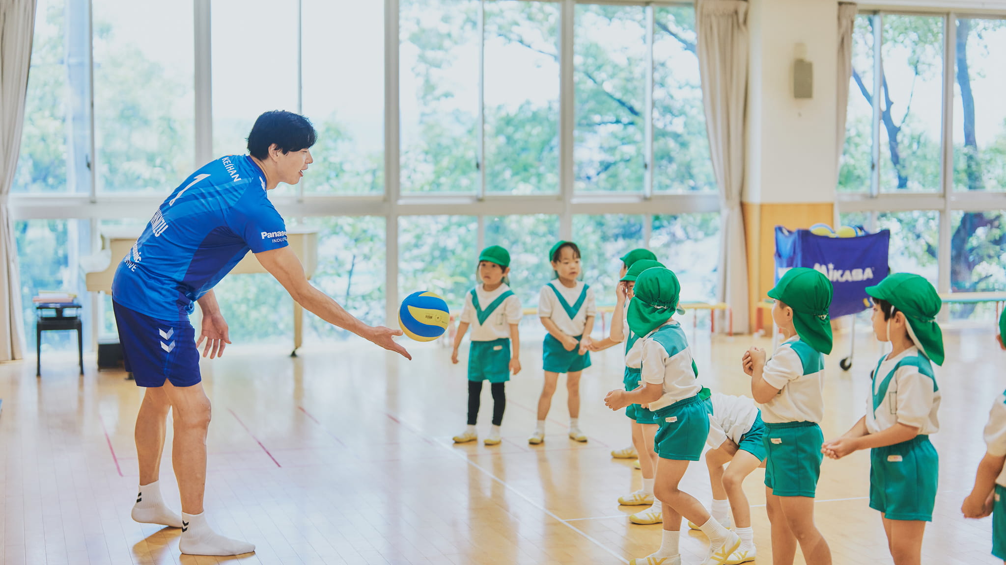 選手と園児が一緒にパスを楽しむ様子
